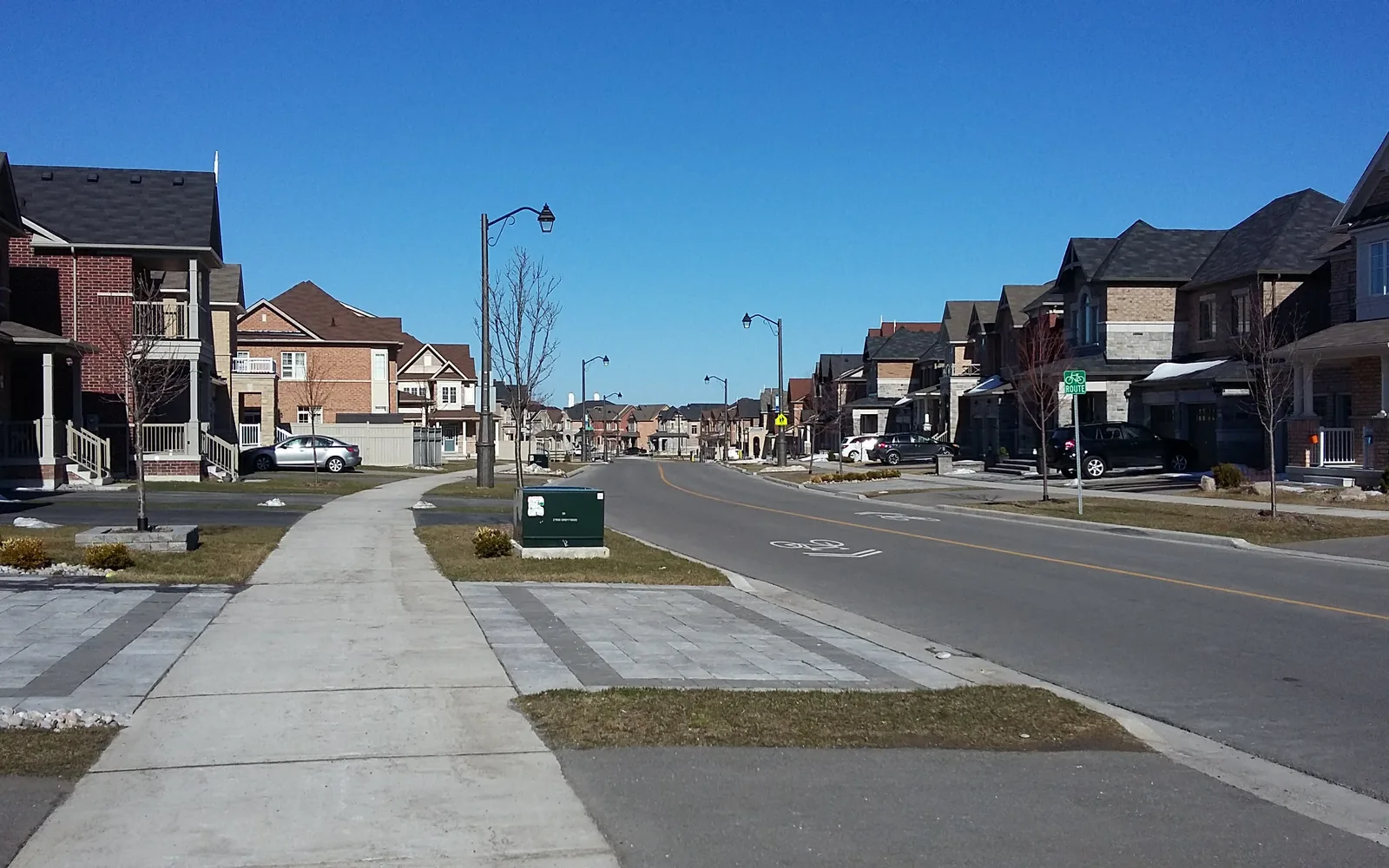 A suburban street lined with trees and residential homes representing typical Orange County neighborhoods